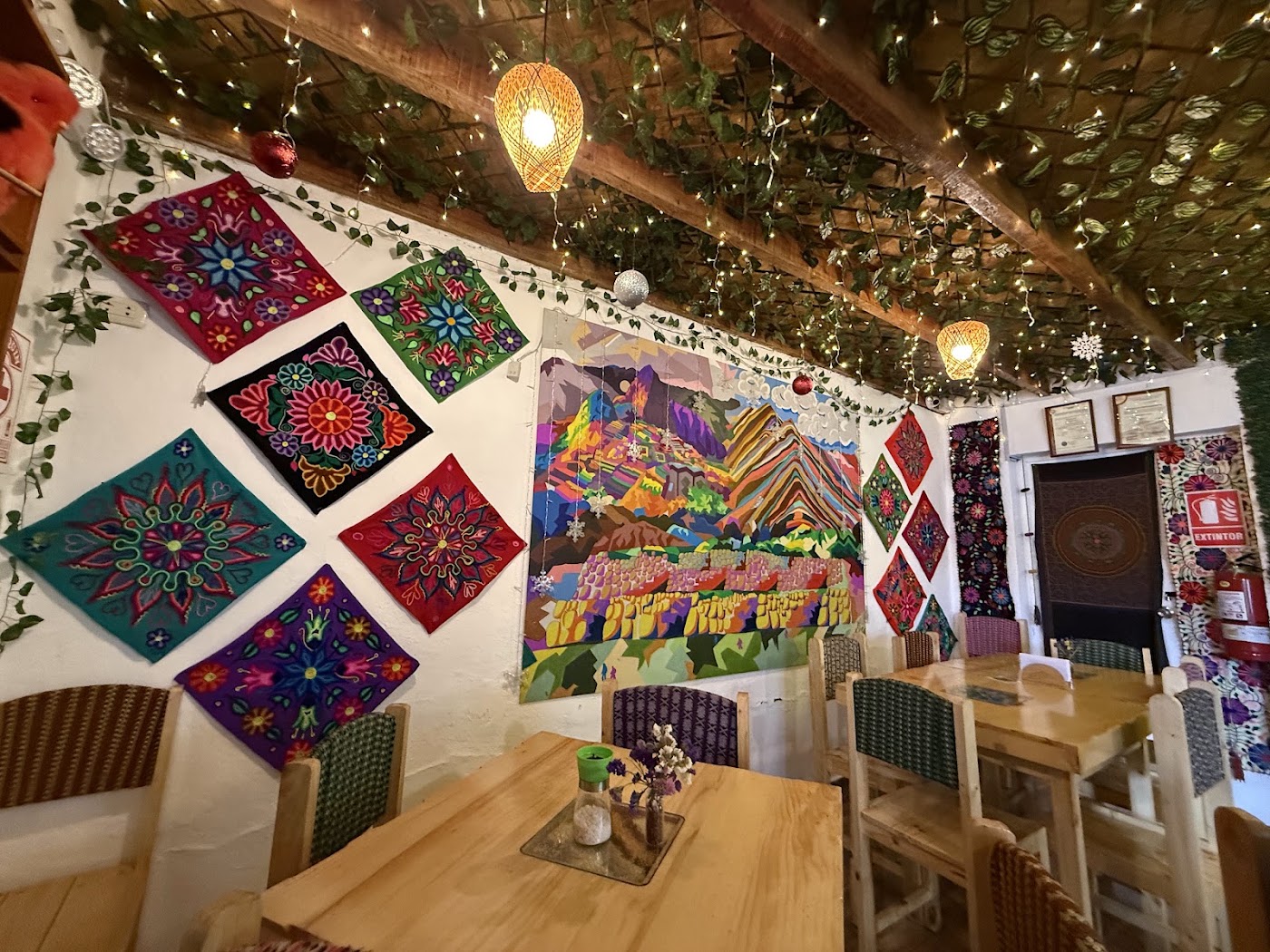 Interior de Something Special Cusco con textiles andinos bordados y mesas de madera