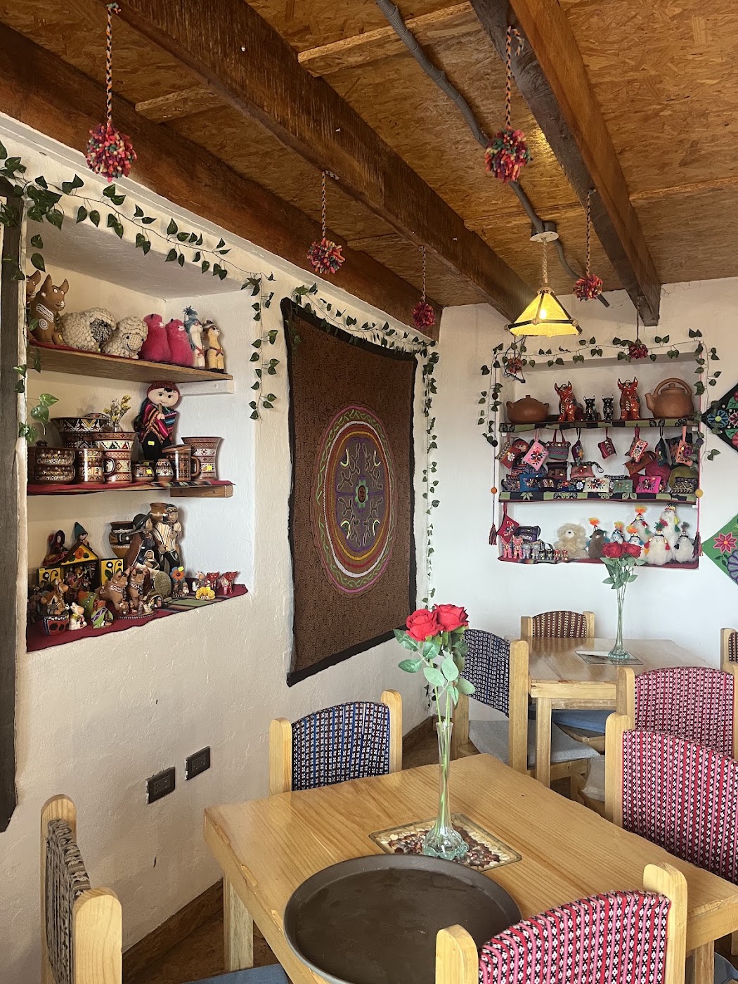 Rincón del comedor con mesas de madera y ventana